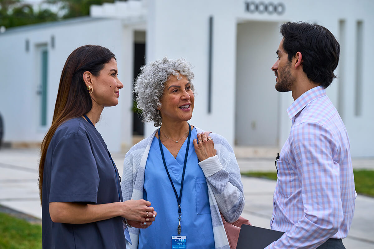 Healthcare workers in conversation outside.