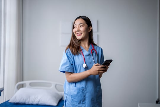 4163_Happy young nurse using smartphone in hospital room