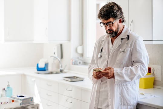 4173_Doctor looking at his phone