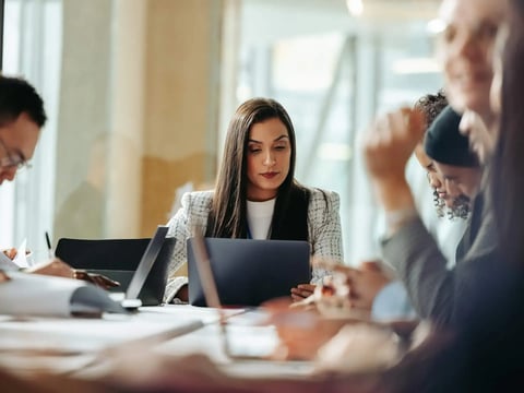 Woman in business meeting looking at laptop screen