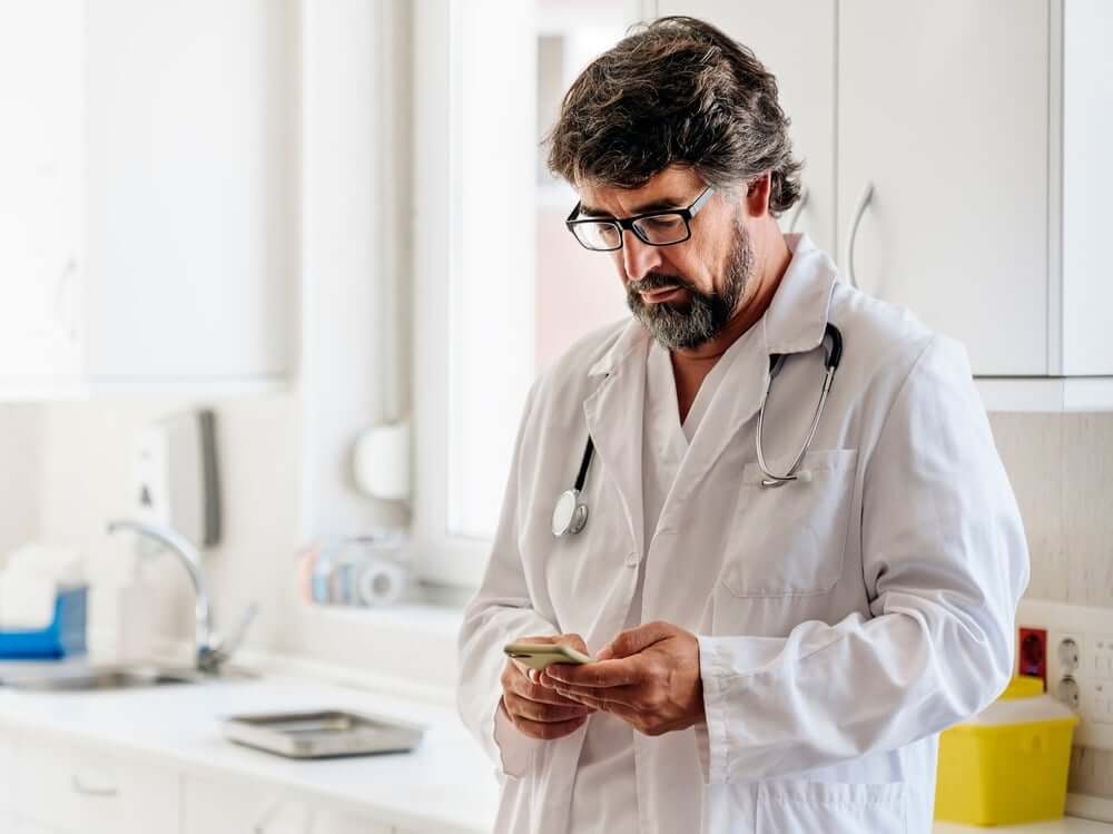 Doctor looking at his phone
