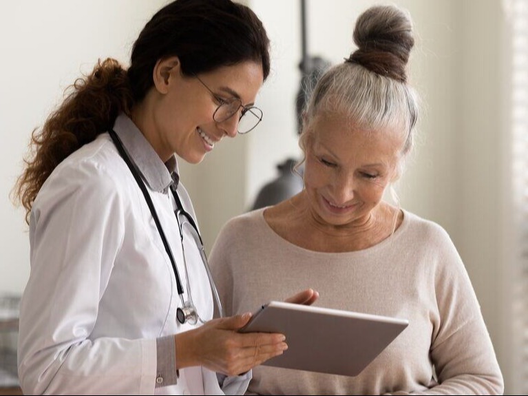Female healthcare provider sharing information with senior citizen